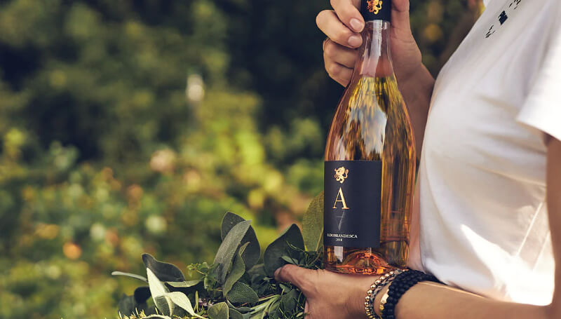 Frau mit Weinflasche im Garten