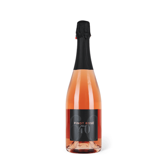 Schaumweinflasche stehend, schwarze Banderole, schwarzes Etikett mit Aufschrift: Pinot Rose Brut