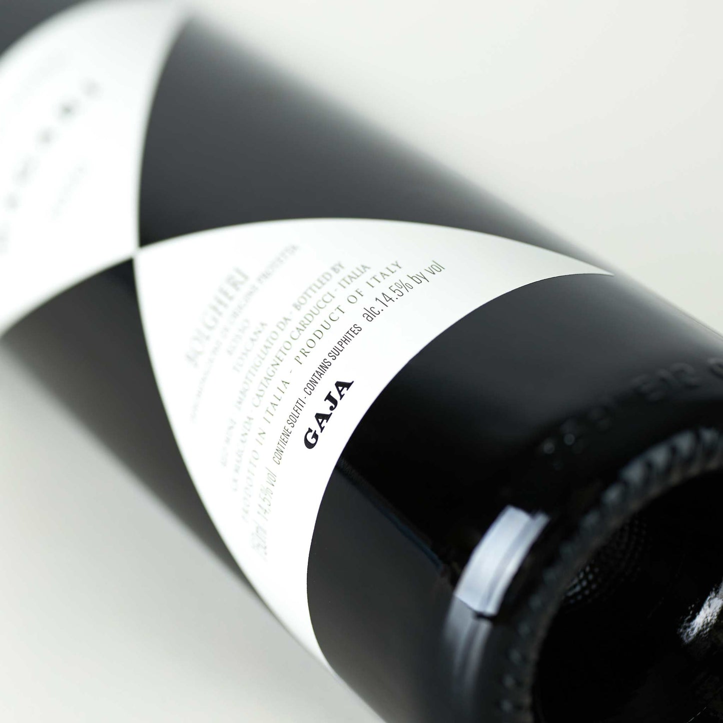 Weinflasche liegend, auf dem schwarz-weiß gemusterten Etikett ist der Name "GAJA" im Mittelpunkt