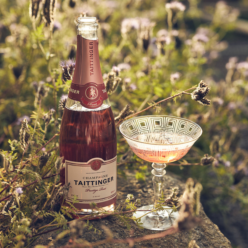 Champagnerflasche mit einem Glas im Lavendelfeld