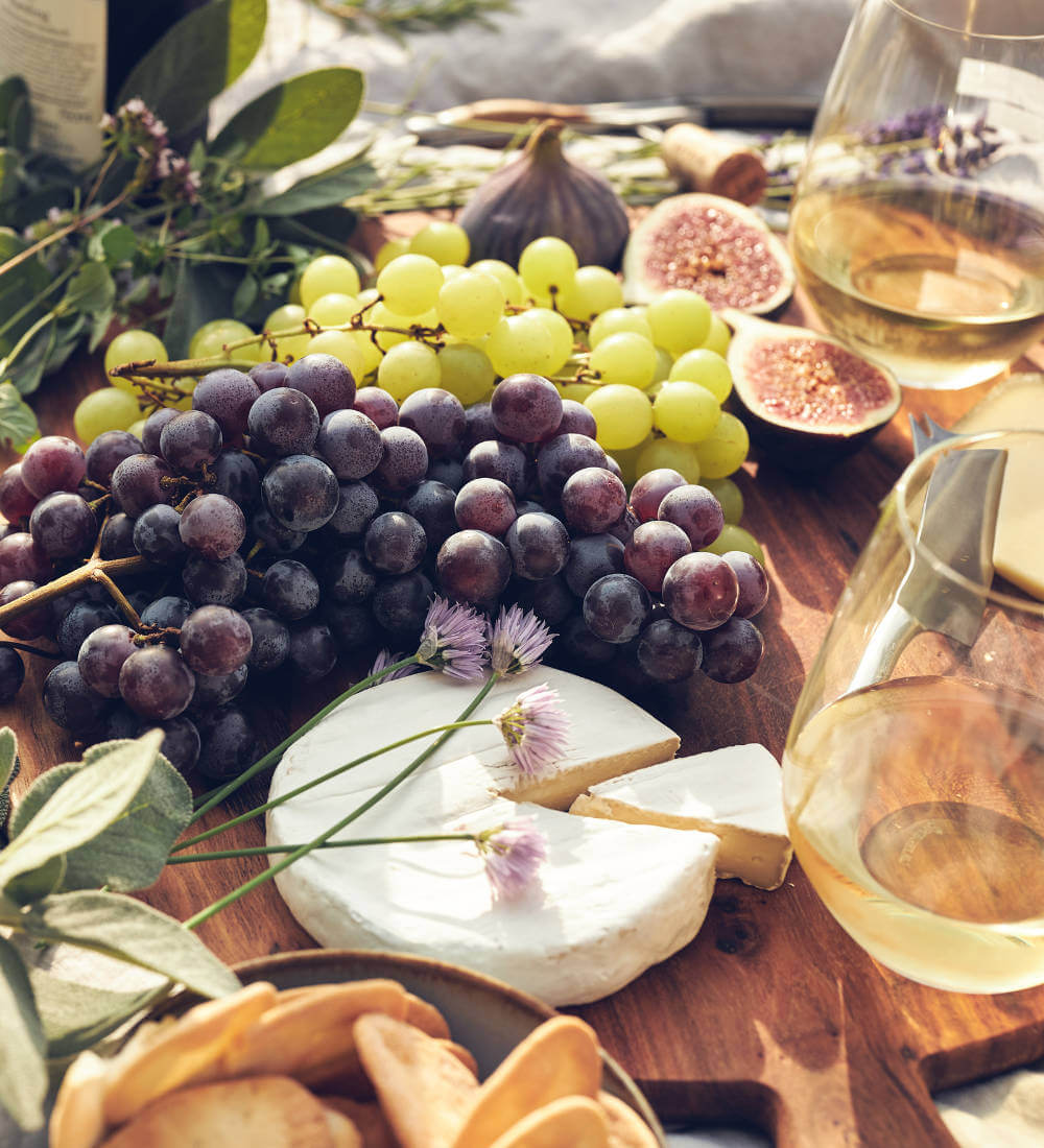 Käseplatte mit Wein und Weintrauben